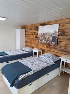 2 łóżka w pokoju z drewnianą ścianą w obiekcie Zimmervermietung KaSa w mieście Groß Lafferde
