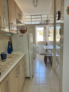 a kitchen with a white refrigerator and a table at Apartamento Central Sétimo Andar in Serra Negra