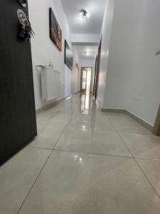 pasillo con paredes blancas y suelo de baldosa en HOME NAS Bragadiru, en Bragadiru