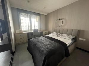 a bedroom with a bed and a desk and a window at VIP APARTAMENT Lubelska in Rzeszów