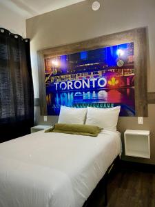 1 dormitorio con 1 cama blanca y una pintura en la pared en Royal Oak Inn en Toronto