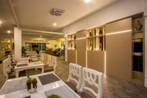 a dining room with white tables and chairs at Sabai Sabana in Pattaya