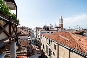 a view of the roofs of buildings with a clock tower at Hotel Colombina in Venice
