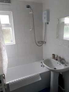 a white bathroom with a sink and a shower at Holiday at Hemsby in Hemsby
