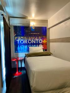 1 dormitorio con 1 cama y una ventana con un cartel en Royal Oak Inn, en Toronto