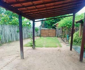 an outdoor pavilion with a fence and a bike in a yard at Casa Barra Jucá - Barra Grande Piauí in Barra Grande