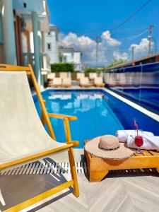 une chaise près de la piscine avec une boisson dans l'établissement Marku Palace, à Ksamil