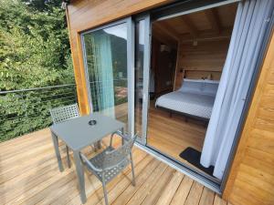 um quarto com uma cama e uma mesa numa varanda em Tree House San Giorgio em Solagna