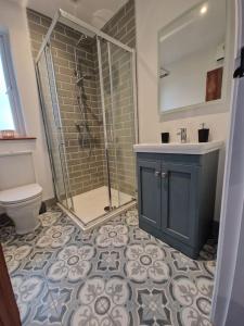 a bathroom with a shower and a sink and a toilet at The Loft at Foxglove Lodge 