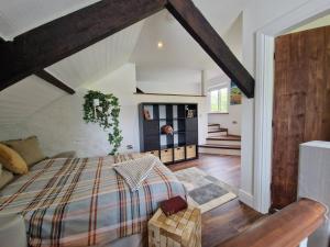 a bedroom with a large bed and a staircase at The Loft at Foxglove Lodge 
