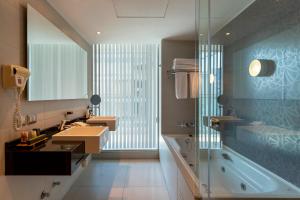 a bathroom with two sinks and a tub and a mirror at Best Western Premier Marina Las Condes in Santiago