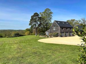 a barn on a grassy hill with a large yard at The Coach House in Shootend