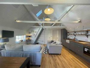 a large living room with a couch and a kitchen at The Coach House in Shootend