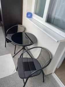 2 chaises et une table devant une fenêtre dans l'établissement HOME NAS Bragadiru, à Bragadiru