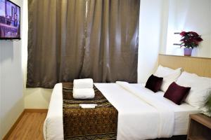 sypialnia z dużym białym łóżkiem i oknem w obiekcie ECO HOTEL at BB w Kuala Lumpur