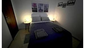 a bedroom with a bed with a blue comforter at Apartamento Próximo do Aeroporto in Lauro de Freitas