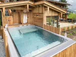 a hot tub in front of a house at Highking Chalet Grünegg in Dienten am Hochkönig