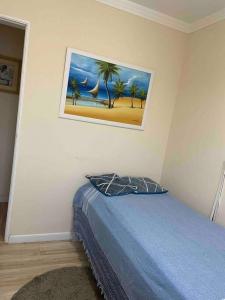a bedroom with a bed with a painting on the wall at Apartamento moderno com 03 quartos e 02 garagens in Campinas