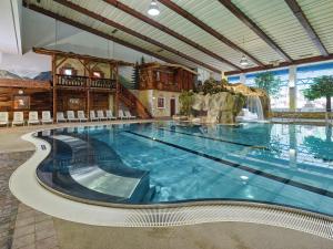 a large swimming pool in a hotel with a waterfall at Appartements Waldesrand in Sölden