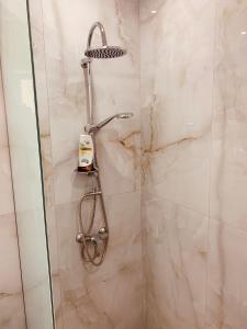 y baño con ducha con cabezal de ducha. en Kampus living, en Faliraki