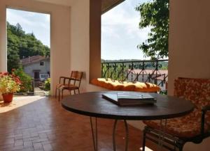 um quarto com uma mesa e cadeiras e uma grande janela em Villa Miranda em Santa Fiora