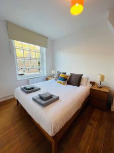 sypialnia z dużym łóżkiem z dwoma ręcznikami w obiekcie Cosy London bedroom near Oval Station - shared bathroom w Londynie