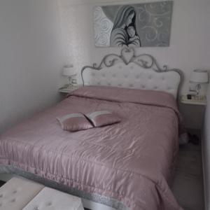 um quarto com uma cama rosa com duas almofadas em La terrazza em Gela