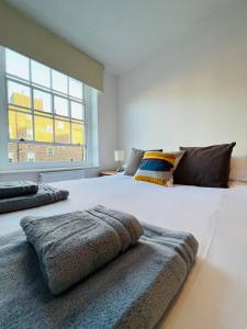 sypialnia z dużym białym łóżkiem i oknem w obiekcie Cosy London bedroom near Oval Station - shared bathroom w Londynie