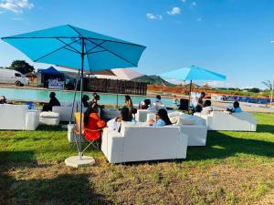 a group of people sitting in chairs under an umbrella at Ten Flags Theme Park in Kroondal