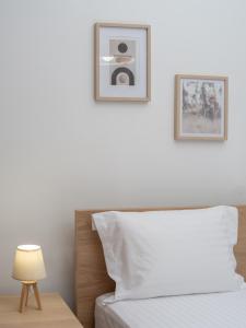 ein Schlafzimmer mit einem Bett und zwei Bildern an der Wand in der Unterkunft Korai City Vibes in Iraklio