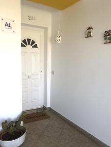 un pasillo con una puerta blanca y una maceta en Casa do Limoeiro, en Albufeira