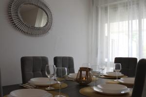 a dining table with wine glasses and a mirror at Casa do Limoeiro in Albufeira