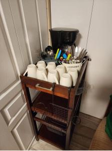 a shelf with cups and utensils on it at Economical Homestay in Burnaby