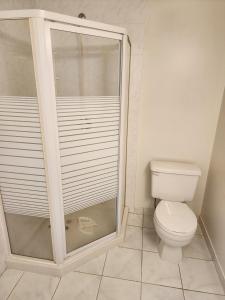 uma casa de banho com um WC e uma cabina de duche em vidro. em Economical Homestay em Burnaby