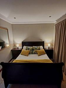 a bedroom with a large bed with two pillows at Lily Rest Garden Cottage in Pretoria