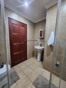 a bathroom with a shower and a toilet and a sink at Lily Rest Garden Cottage in Pretoria