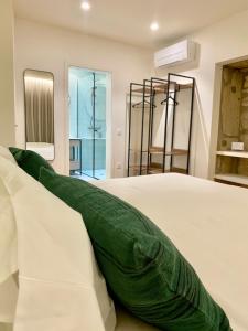 a white bed with a green pillow on it at Misericórdia Garden Homes in Vila do Conde