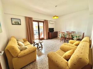 a living room with two couches and a dining room at Hostal y Apartamentos Santa Eulalia in Santa Eularia des Riu