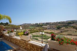 a view from the balcony of a house with flowers at Carini Farmhouses in Għarb