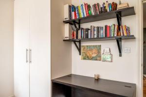 a desk in a room with bookshelves at Bright & Spacious Battersea Flat in London