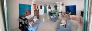 a living room with two blue couches and a living room with at Residence Baja Sardinia in Baja Sardinia
