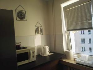 una cucina con forno a microonde su un bancone con finestra di mieszkanie w Giżycku a Giżycko