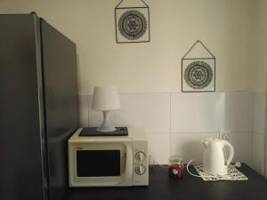 un four micro-ondes sur une table avec une lampe au-dessus dans l'établissement mieszkanie w Giżycku, à Giżycko