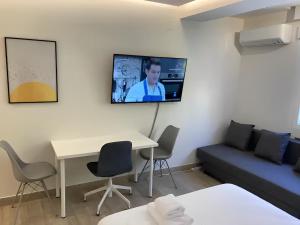 a living room with a couch and a tv on a wall at Castellana 4 torres Apartments in Madrid