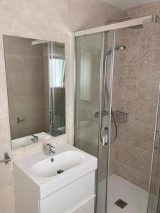 a bathroom with a white sink and a shower at Castellana 4 torres Apartments in Madrid