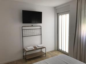 sypialnia z telewizorem na ścianie i łóżkiem w obiekcie Trasariz Suites 1 w mieście Vimianzo