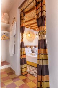 a bedroom with a bed and curtains in a room at Dar Khmissa Riad & Spa in Marrakech