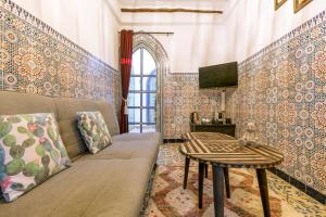 a living room with a couch and a table at Dar Khmissa Riad & Spa in Marrakesh