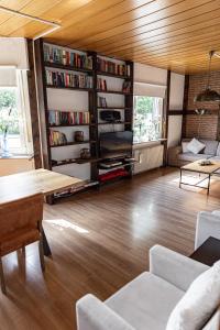 een woonkamer met houten vloeren en boekenplanken bij Anil‘s Ferienhaus in Olsberg