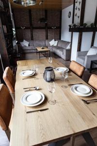 a wooden table with plates and wine glasses on it at Anil‘s Ferienhaus in Olsberg